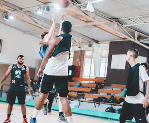 group of men playing basketball in a gym