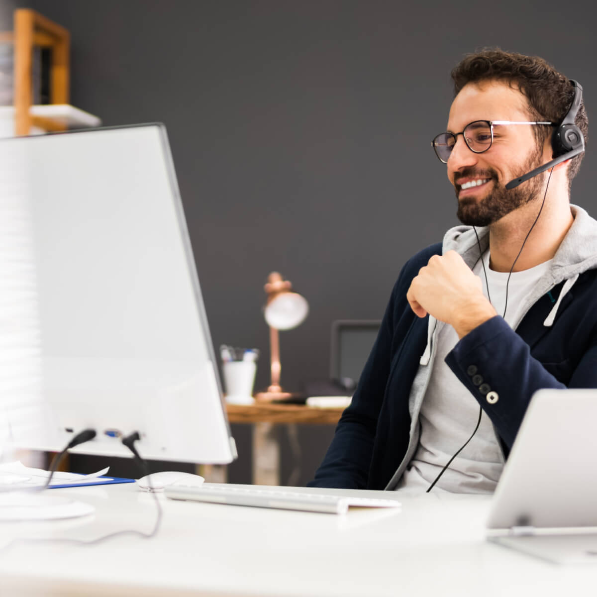 young male attending a webinar on his computer in an office