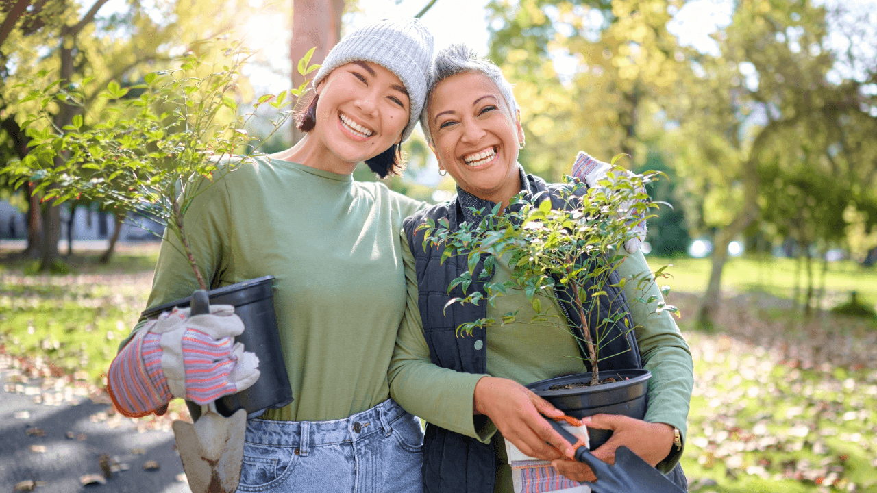 two women holding plants